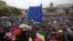 U.K. -- A demonstrator waves a European flag as people shelter under umbrellas at an anti-Brexit protest on Trafalgar Square in central London, June 28, 2016