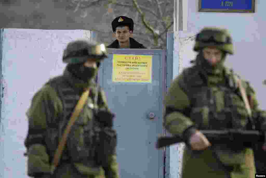 Украинские военные части на территории Крыма были заблокированны российскими войсками. Украинский солдат из части в Перевальном выглядывает из-за забора, 3 марта 2014