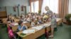 ODESSA, UKRAINE - 24 September 2015: children of primary school and teacher in the classroom. Study of first-graders in the school. Children go to school the first of September, the Day of Knowledge