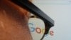 A journalist looks at the new Google logo at his work station in Washington