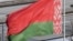 (FILES) A woman pushes a stroller under the Belarus' national flag in Minsk on January 23, 2019. (Photo by Kirill KUDRYAVTSEV / AFP)