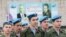 Russia -- Participants line up during a ceremony for potential conscripts at a military base, with the portraits of Russian President Vladimir Putin (L) and Defence Minister Sergei Shoigu seen in the background, on the Conscript Day in Stavropol, April 14