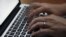 FILE - This June 19, 2017 file photo shows a person working on a laptop in North Andover, Mass. (AP Photo/Elise Amendola, File)
