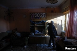 Алина стоит в своем доме, который был поврежден в результате, как заявили российские власти, удара украинского беспилотника в Донецке, городе Украины, контролируемом Россией. 17 января 2026 года. Фото REUTERS