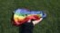 A woman with a rainbow flag lays on grass during the LGBT (lesbian, gay, bisexual, and transgender) community rally "VIII St.Petersburg Pride" in St. Petersburg, Russia August 12, 2017. REUTERS/Anton Vaganov