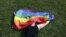 A woman with a rainbow flag lays on grass during the LGBT (lesbian, gay, bisexual, and transgender) community rally "VIII St.Petersburg Pride" in St. Petersburg, Russia August 12, 2017. REUTERS/Anton Vaganov