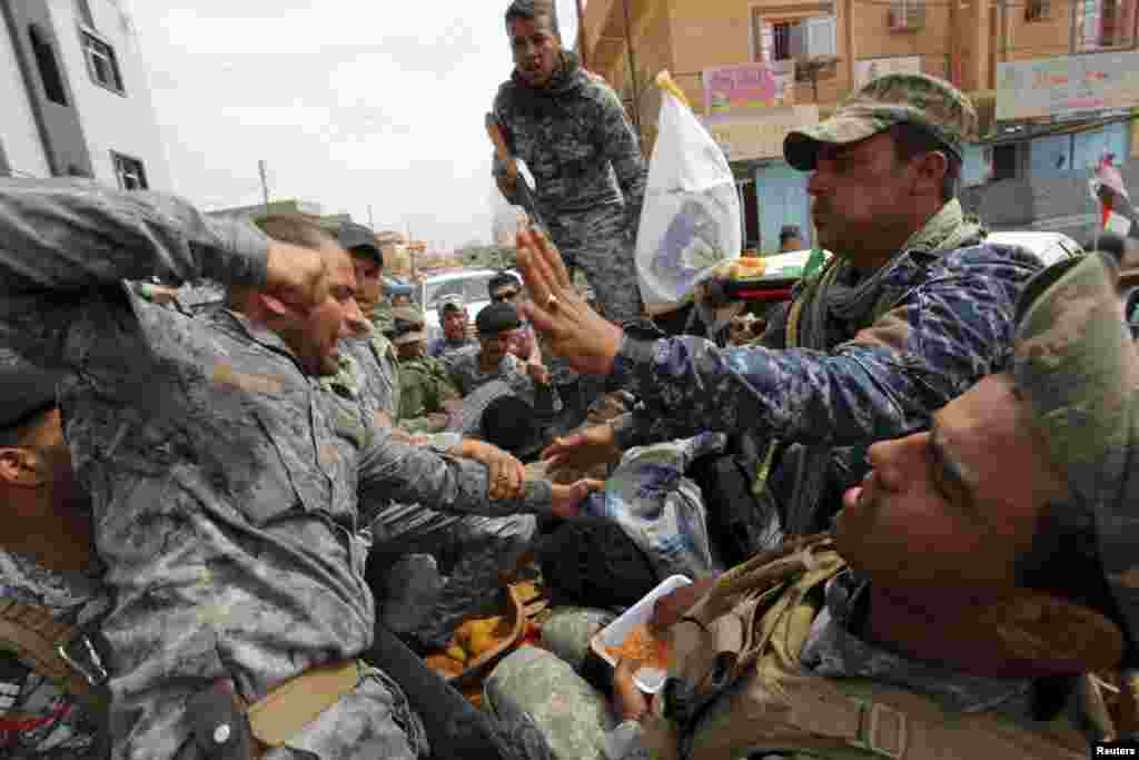 Один из иракских военнослужащих бьет взятого в плен в Тикрите боевика, воюющего на стороне террористической организации &quot;Исламское государство&quot;