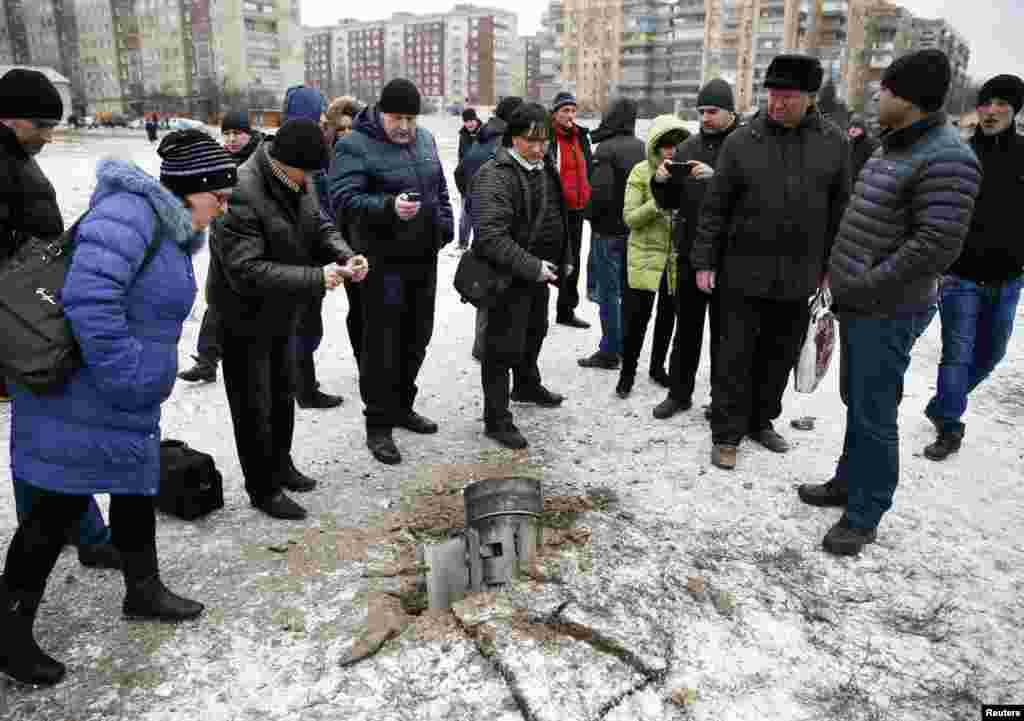 Люди осматривают реактивный снаряд, упавший на одной из улиц Краматорска &nbsp;