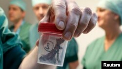 Хирург демонстрирует осколок, извлеченный из тела пострадавшего от взрывов в Брюсселе