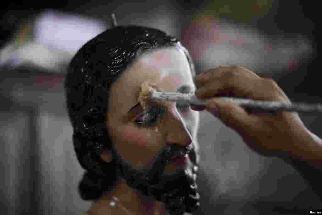 Хозе Гомес наносит тальк на лицо статуи Иисуса Христа в своей мастерской в&nbsp;Апастепеку. Тальк нужен, чтобы заполнить поры дерева и чтобы краска лучше держалась на поверхности скульптуры&nbsp;
