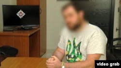 Один из задержанных в футболке с украинским трезубцем