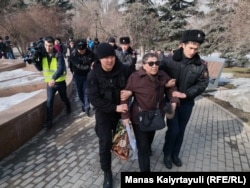 Полицейские уводят женщину, пришедшую на площадь Астана. Алматы, 22 февраля 2020