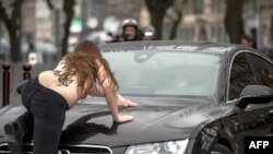 Активистка группы Femen запрыгивает на капот машины бывшего главы МВФ Доминика Страусс-Кана, 10 февраля 2015