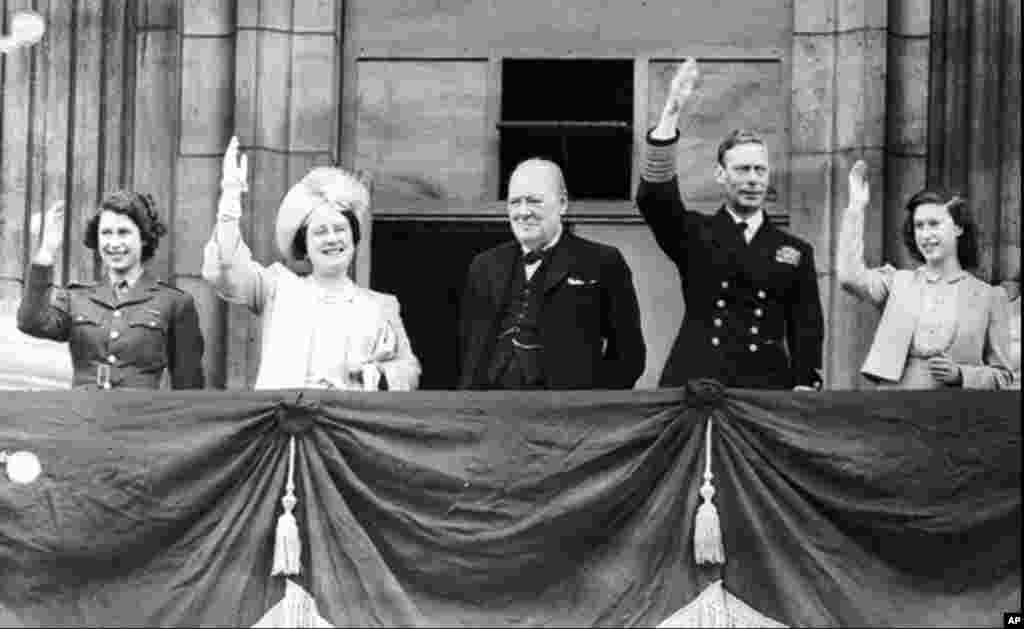 Принцесса Елизавета (крайняя слева, в военной форме) на балконе Букингемского дворца с отцом, королем Георгом VI, матерью, королевой Элизабет, сестрой, принцессой Маргарет, и премьером Уинстоном Черчиллем