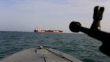 IRAN -- A speedboat of Iran's Revolutionary Guard trains a weapon toward the British-flagged oil tanker Stena Impero, which was seized in the Strait of Hormuz on Friday by the Guard, in the Iranian port of Bandar Abbas, July 21, 2019