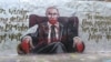 В Берлине появилось панно ко дню рождения Путина. Через день на нем написали "Убийца и вор"