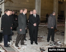 Лукашенко в окружении сотрудников службы безопасности осматривает место взрыва в минском метро 12 апреля 2011 года