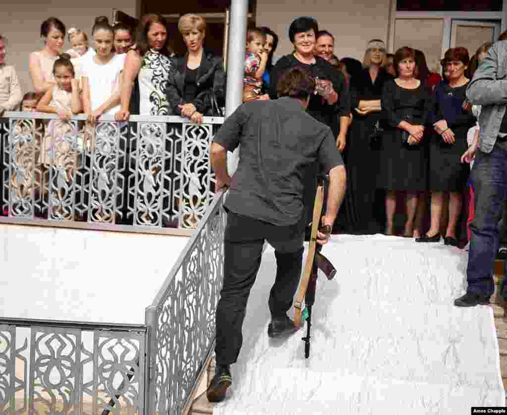 Человек с автоматом на абхазской свадебной церемонии. В Абхазии свадьбы и рождения мальчиков традиционно отмечаются выстрелами в воздух