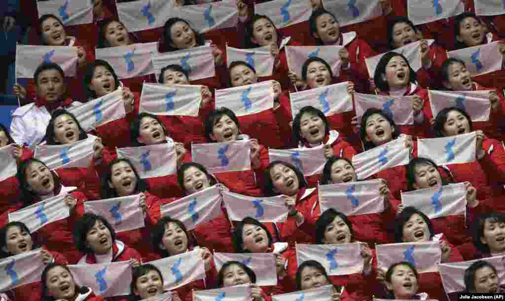 Девушки держат в руках флаг объединенной Кореи во время шорт-трек забега на 500 метров среди женщин. 10 февраля 2018