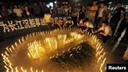 Люди зажигают свечи в память о погибших пассажирах "Звезды Востока"