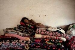 Девочка из деревни ромов спит на горе из перин и одеял. 2010