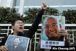 Гонконгские активисты с плакатами в поддержку Ву Гана