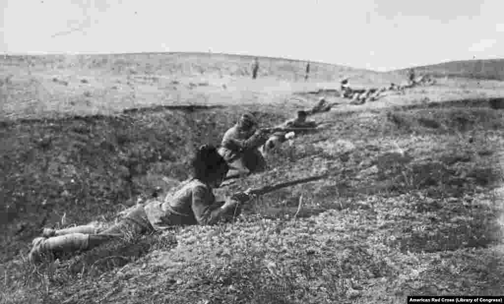 Бойцы-белогвардейцы, некоторые в казачьих шапках, на позициях для наступления (юг России)