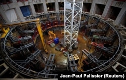 Техники работают внутри здания, где будут изготовлены четыре катушки полоидального поля на строительной площадке Международного термоядерного экспериментального реактора ITER в окрестностях Сен-Поль-ле-Дюранс в Провансе
