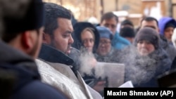 Священник читает молитву на похоронах в Магнитогорске