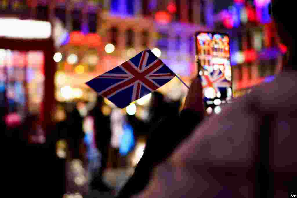 Женщина фотографирует флаг Великобритании во время мероприятия, посвященного дружбе между Бельгией и Великобританией, на Гран-Плас в Брюсселе, 30 января 2020 года. Великобритания вышла из ЕС 31 января