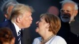 FRANCE -- U.S. President Donald Trump kisses German Chancellor Angela Merkel during the G7 family photo in Biarritz, August 25, 2019