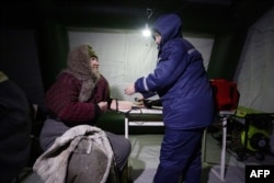 Врач измеряет давление женщине в палатке для обогрева. 31 января 2017