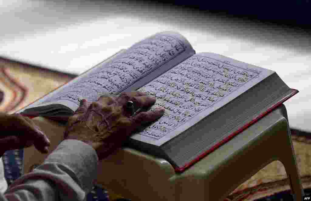 Считается, что традиция празднования окончания самого длительного и строгого поста берет свое начало с 624 года На фото &ndash; мужчина читает Коран в одной из мечетей пакистанского города Карачи. 13 июля 2016