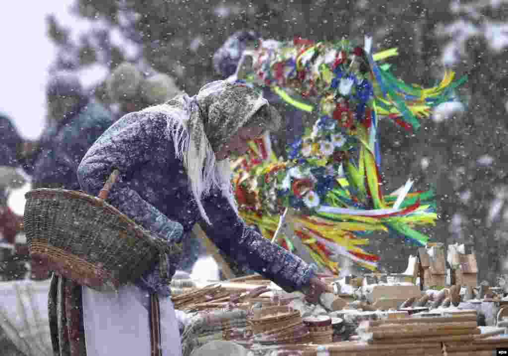 Женщина выбирает подарки во время масленичной ярмарки в белорусском селе Озерцо