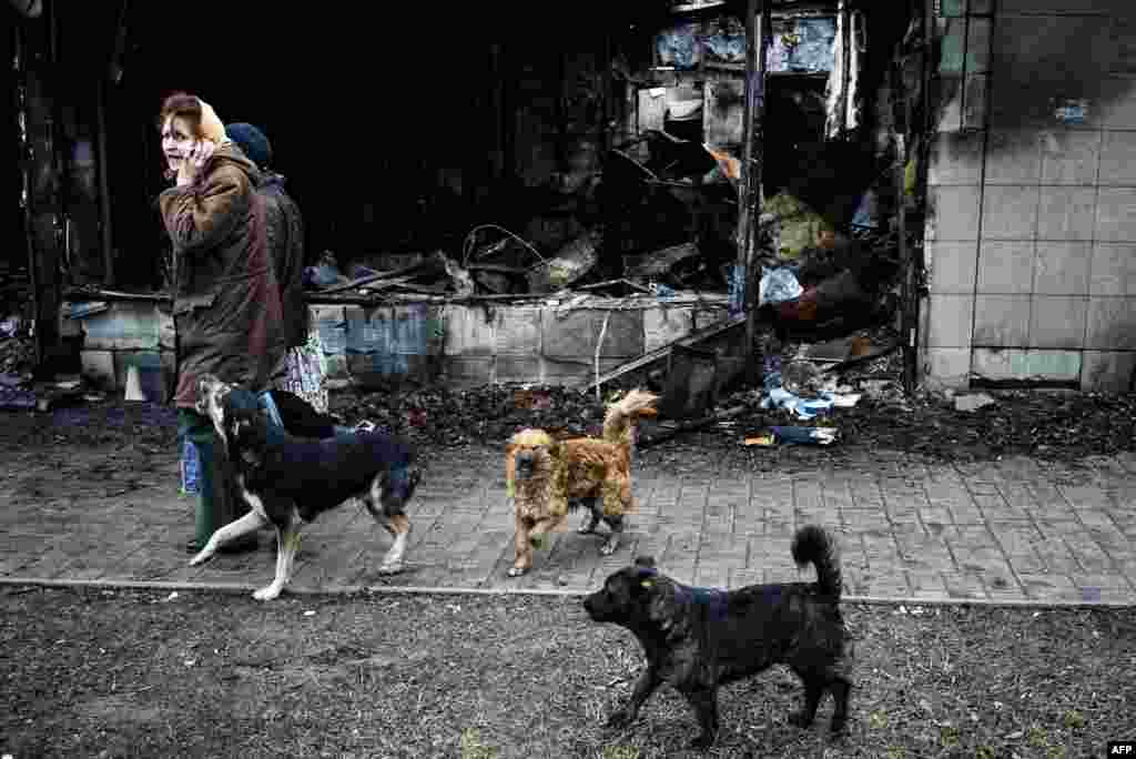 Женщины проходят мимо сгоревшего магазина в Киевском районе Донецка