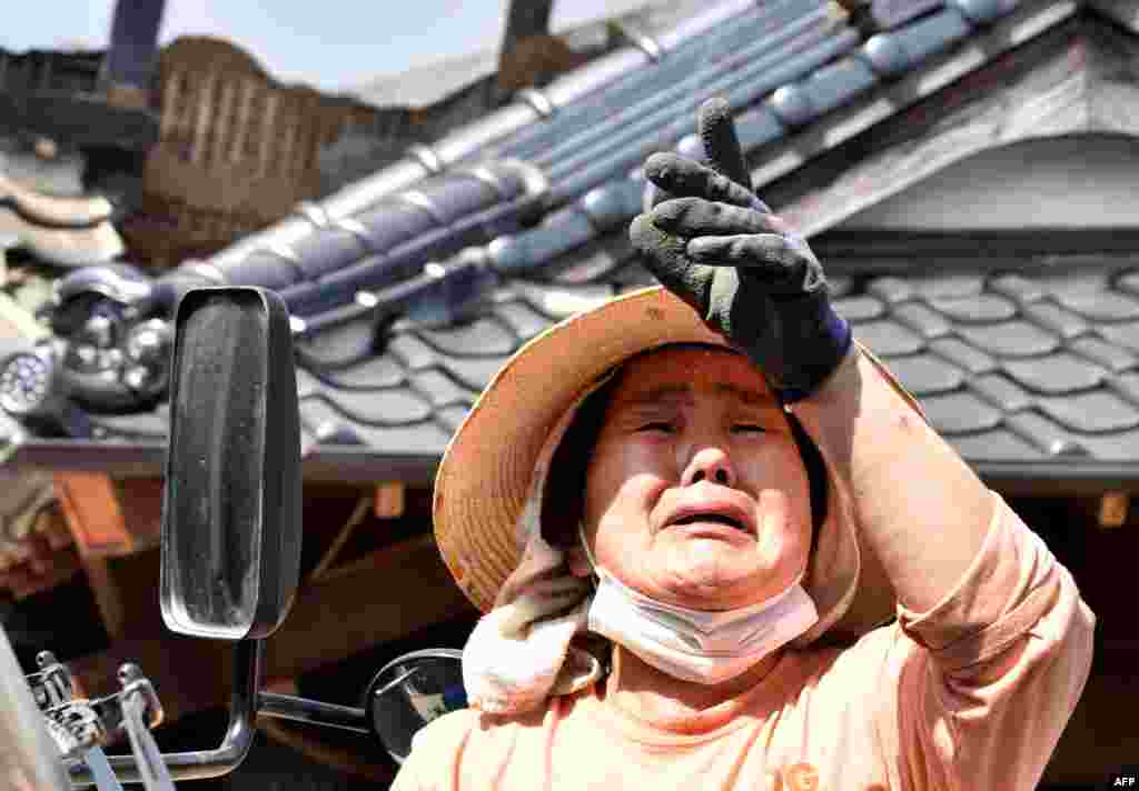 Мощное землетрясение произошло вечером в четверг На фото &ndash; женщина плачет, рассказывая о своем разрушенном доме в городе Машики, префектура Кумамото