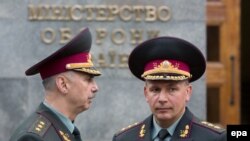 Newly appointed Defense Minister Valeriy Heletey (right) and former acting Defense Minister Mykhaylo Koval (left) talk in front of Defense Ministry headquarters in Kyiv July 3.
