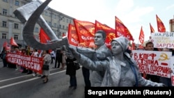 Пара участвует в первомайском шествии в Москве, изображая памятник "Рабочий и колхозница" работы Веры Мухиной. Фото: Reuters