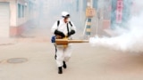 A worker in protective suit disinfects the Dongxinzhuang village, as the country is hit by the new coronavirus