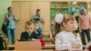 First-grade students and teacher are in school classroom at first lesson