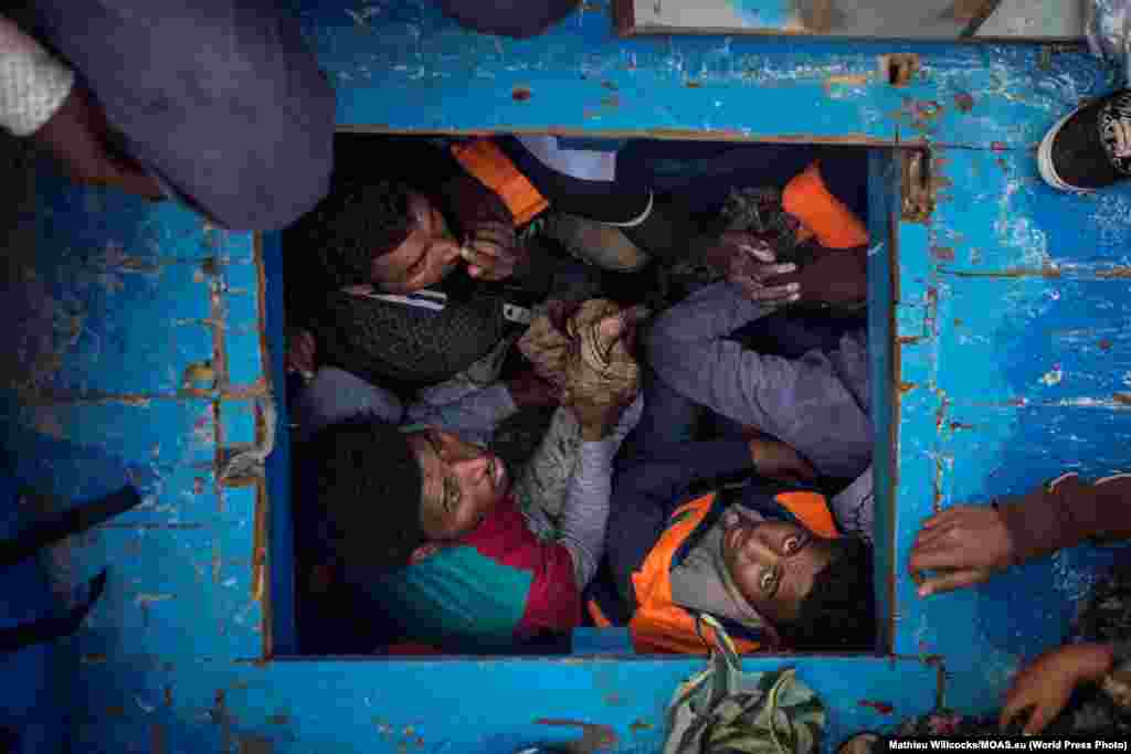 Третий приз в категории &quot;Новости&quot;: беженцы из Эритреи в деревянной лодке, пересекающей Средиземное море. В момент съемки на борту было около 540 человек. Фото &ndash; Мэтью Уиллокс