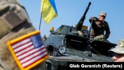 A U.S. Army instructor is seen near Ukrainian servicemen during the Rapid Trident 2019 drills, in which 14 NATO and partner countries participated near Lviv, Ukraine.