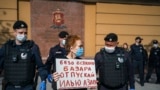 Police officers in Moscow detain Russian photographer Viktoria Ivleva during her May 28 solo protest outside of police headquarters in support of jailed journalist and activist Ilya Azar. "Release Ilya Azar without any fuss," her sign reads. 