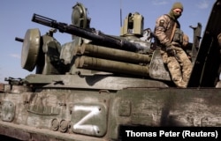 Украинский солдат на отбитой у российских военных артиллерийской установке с маркировкой "Z". 29 марта 2022 года. Фото: Reuters
