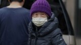 New York City, U.S. - A young resident of Chinatown wears a surgical mask 