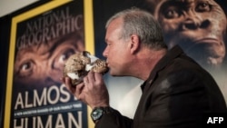 Профессор Ли Бергер целует череп Homo Naledi в ходе презентации открытия