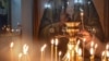 KYRGYZSTAN - A woman lights a candle in a church in Bishkek on January 7, 2019
