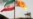 A gas flare on an oil production platform in the Soroush oil fields is seen alongside an Iranian flag in the Persian Gulf, Iran, July 25, 2005. 