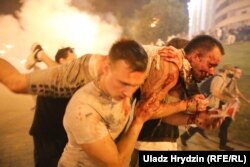 Участники протестов против официальных результатов президентских выборов в Беларуси несут раненого человека. Беларусь, 9 августа (Влад Грыдзин)