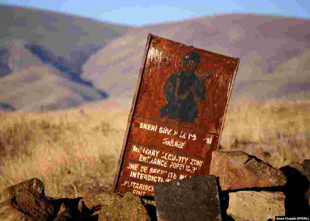 Старый знак, который сообщает, что Ани - часть милитаризованной зоны. Турция полностью закрыла границу с Арменией в 1993 году, после начала конфликта в Нагорном Карабахе, в котором она поддерживала Азербайджан. Тогда же на границе была создана милитаризованная зона, в которую вход был воспрещен. Сегодня Турция в целом сняла ограничения на посещение Ани, но некоторые районы города-памятника по-прежнему недоступны туристам и историкам